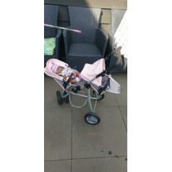 Baby born tweelingpoppenwagen met bruine pop met nieuw setje